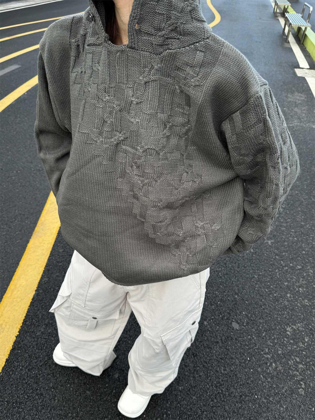 Gray knitted sweater hoodie by TALISHKO, worn with white cargo pants, highlighting street style.