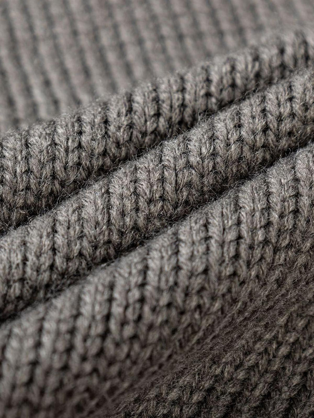 Intricate look at the gray knitted texture of the TALISHKO asymmetric sweater hoodie.
