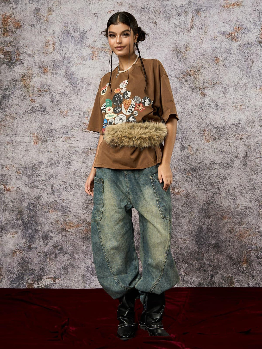 Model in brown TALISHKO T-shirt with badge print and jeans, exuding effortless style.