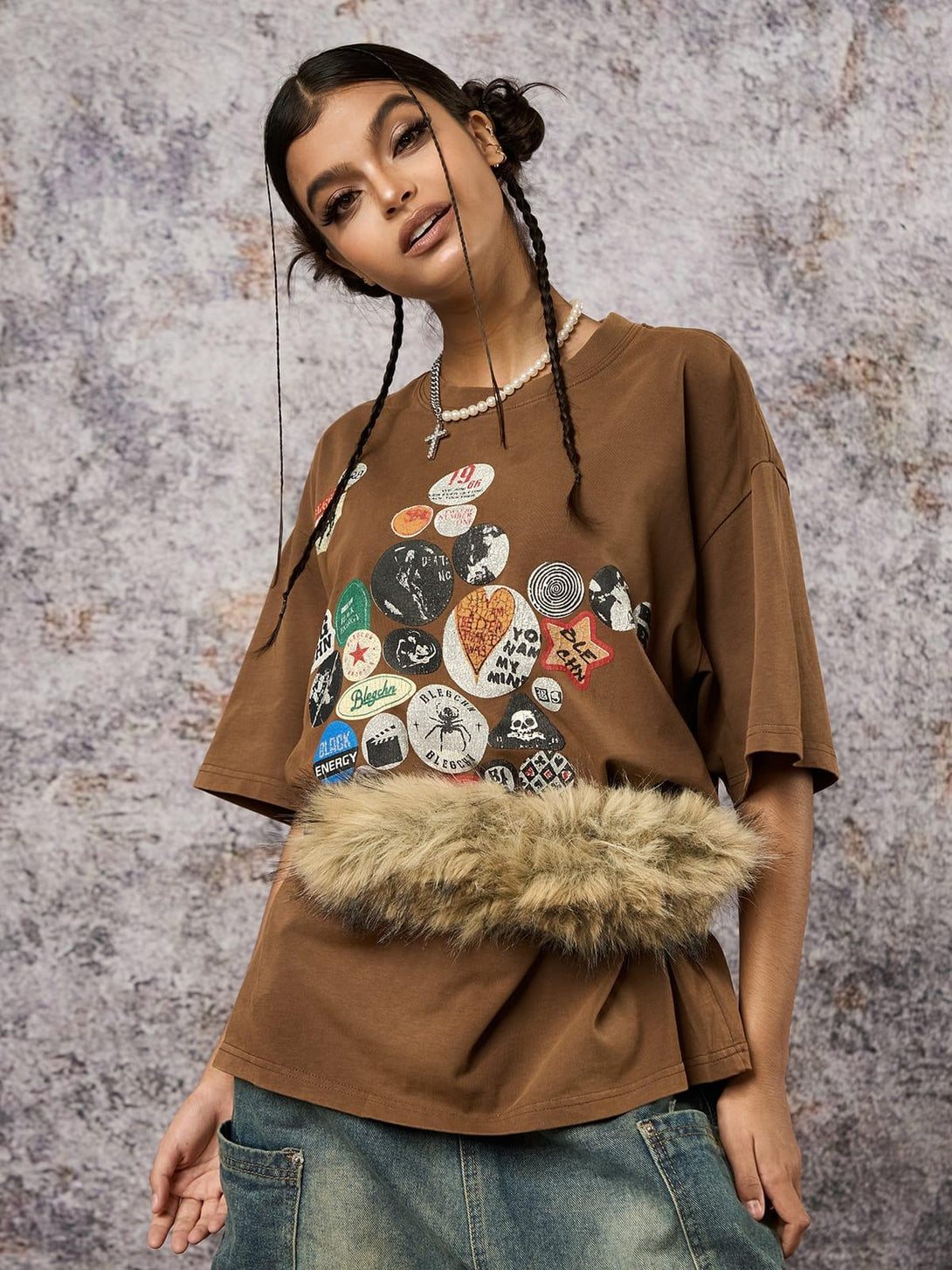 Model in brown TALISHKO tee with badge print and faux fur detail, showcasing casual style.