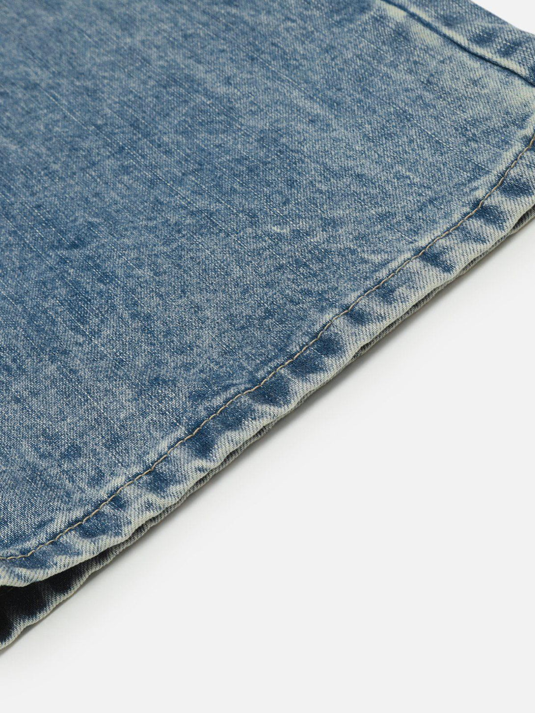 Detailed fabric and stitching of TALISHKO barrel baggy jeans, showcasing the faded denim texture.