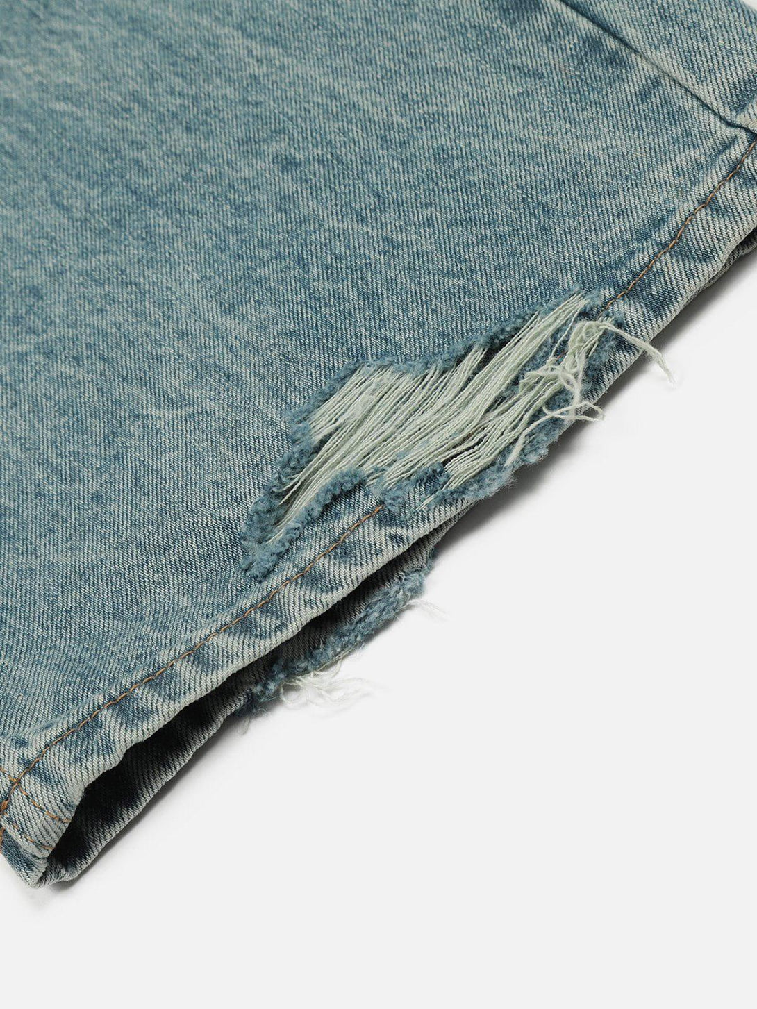 A detailed view of TALISHKO's distressed loose jeans, highlighting frayed hem and texture.