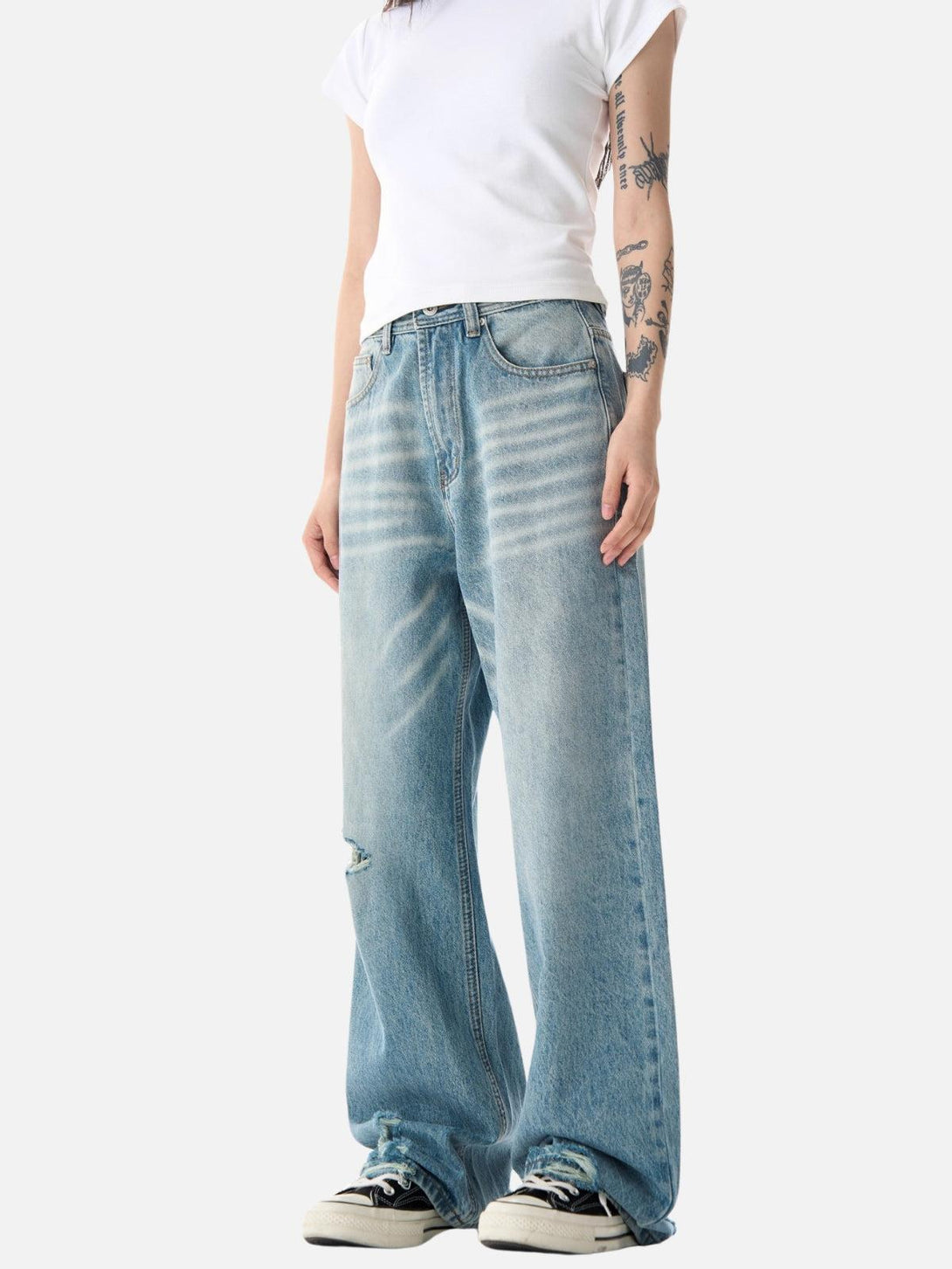 Model styled in TALISHKO's distressed loose jeans and white tee, embodying relaxed urban fashion.