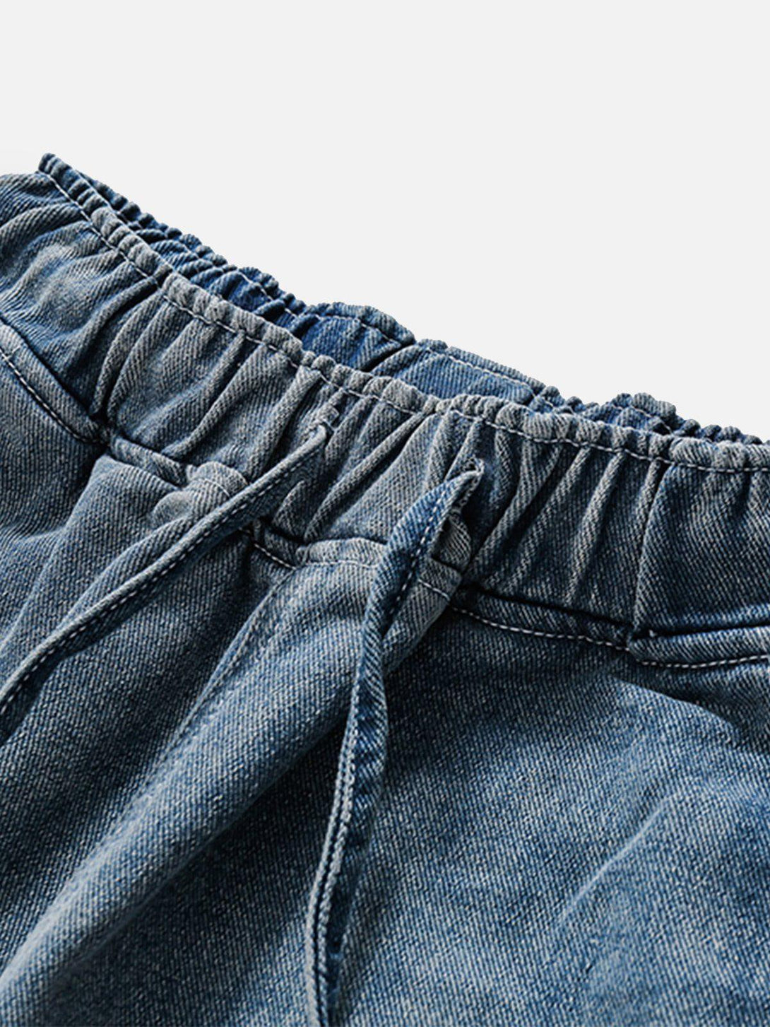 Intricate look at TALISHKO's blue jorts, highlighting the drawstring waist and washed denim.