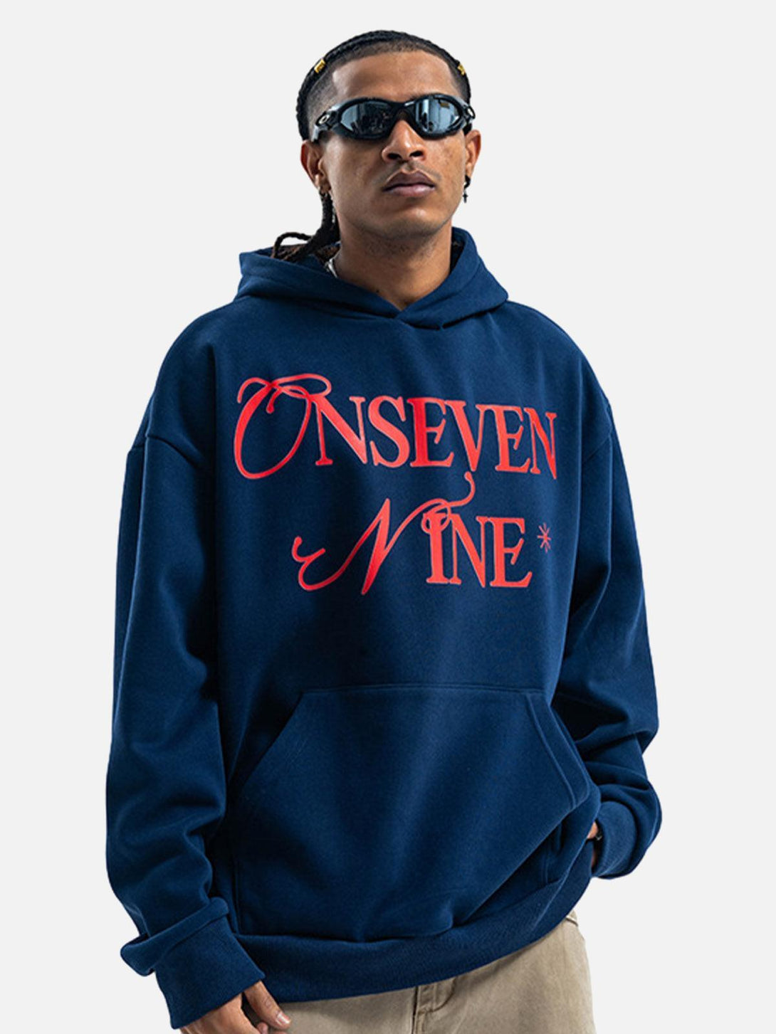 Model in a navy fleece hoodie by TALISHKO with bold red lettering, exuding a stylish vibe.
