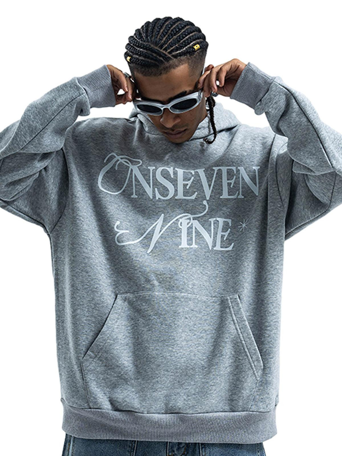 Model in a gray fleece hoodie by TALISHKO, featuring stylish lettering for a trendy look.