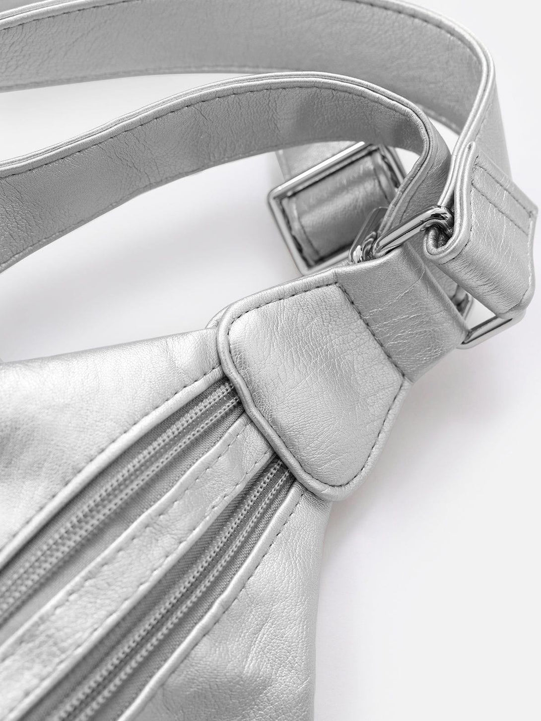 Focusing on the intricate strap detail of the TALISHKO faux leather bag, showcasing craftsmanship.