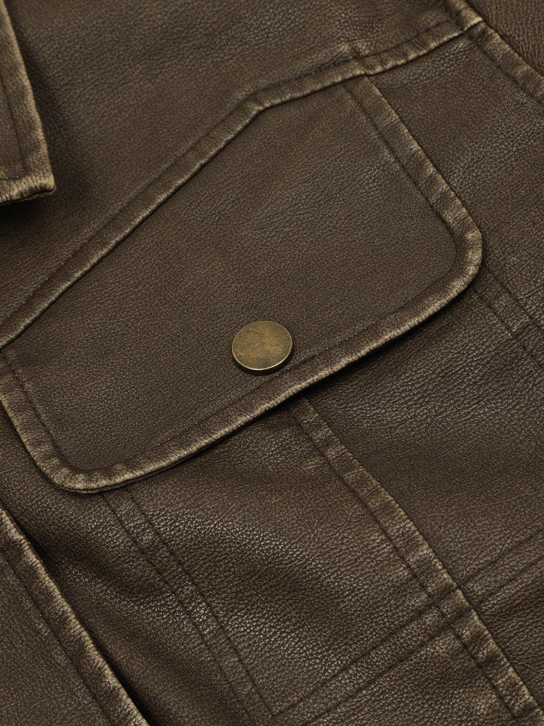 Detailed look at the pocket of a brown faux leather jacket by TALISHKO, highlighting texture.
