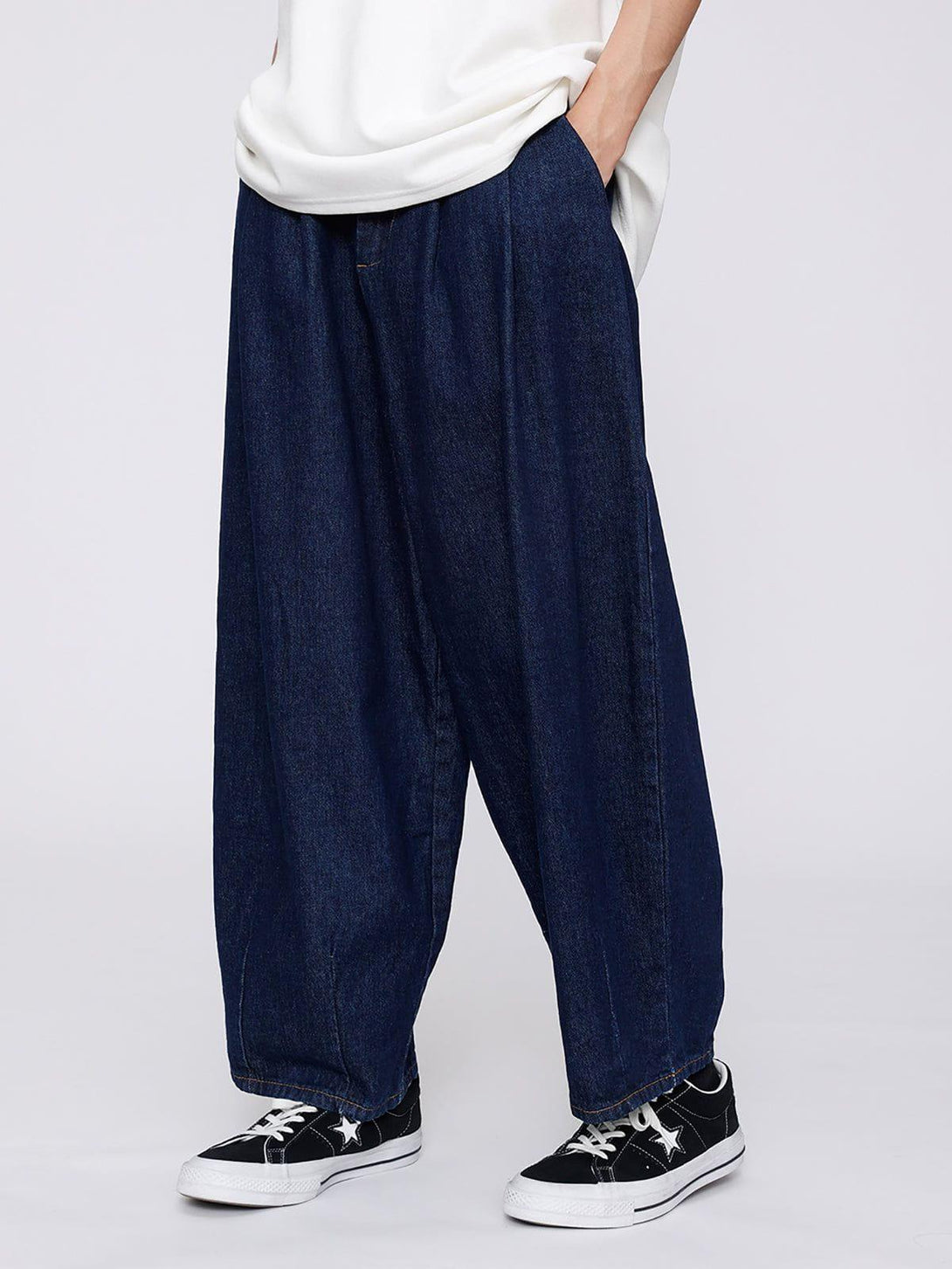 Model in TALISHKO baggy jeans, paired with a white top and sneakers, showcasing a relaxed fit.