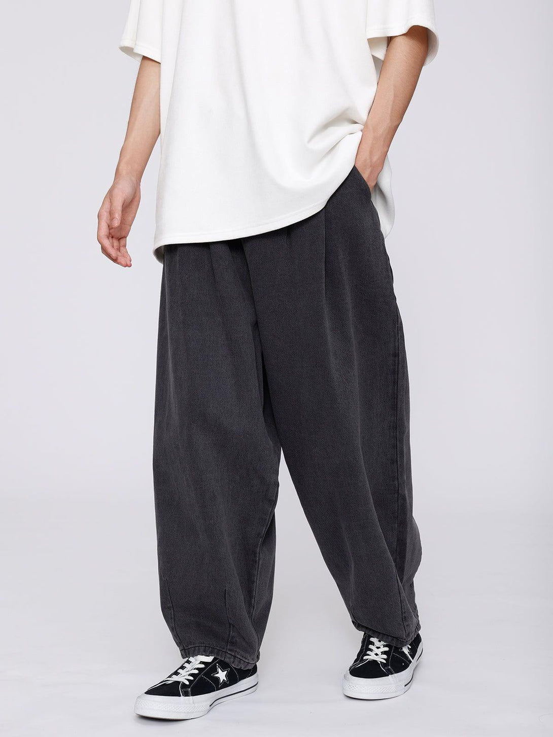Model wearing TALISHKO baggy jeans, paired with a white top and sneakers for a relaxed look.