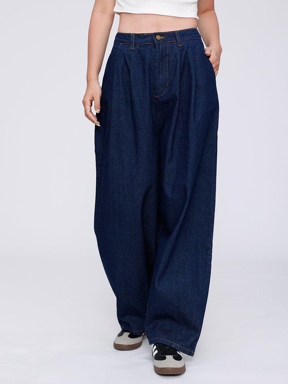 Model wearing TALISHKO baggy jeans, styled with a white top and sneakers for a casual vibe.