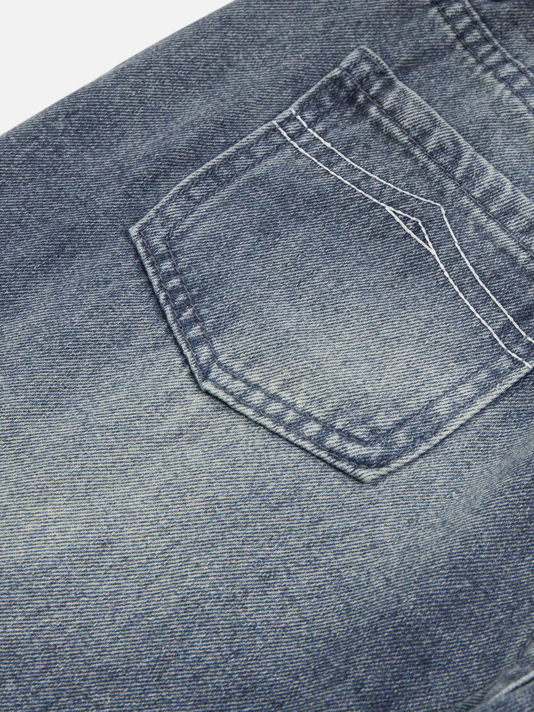 Zoomed-in texture of TALISHKO's washed denim, highlighting back pocket stitching detail.