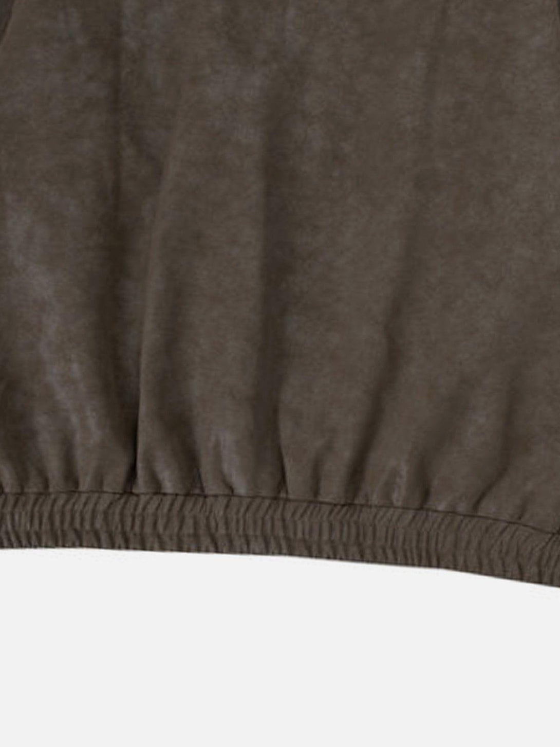 A close-up of TALISHKO's faux leather jacket, highlighting the elastic hem and texture.