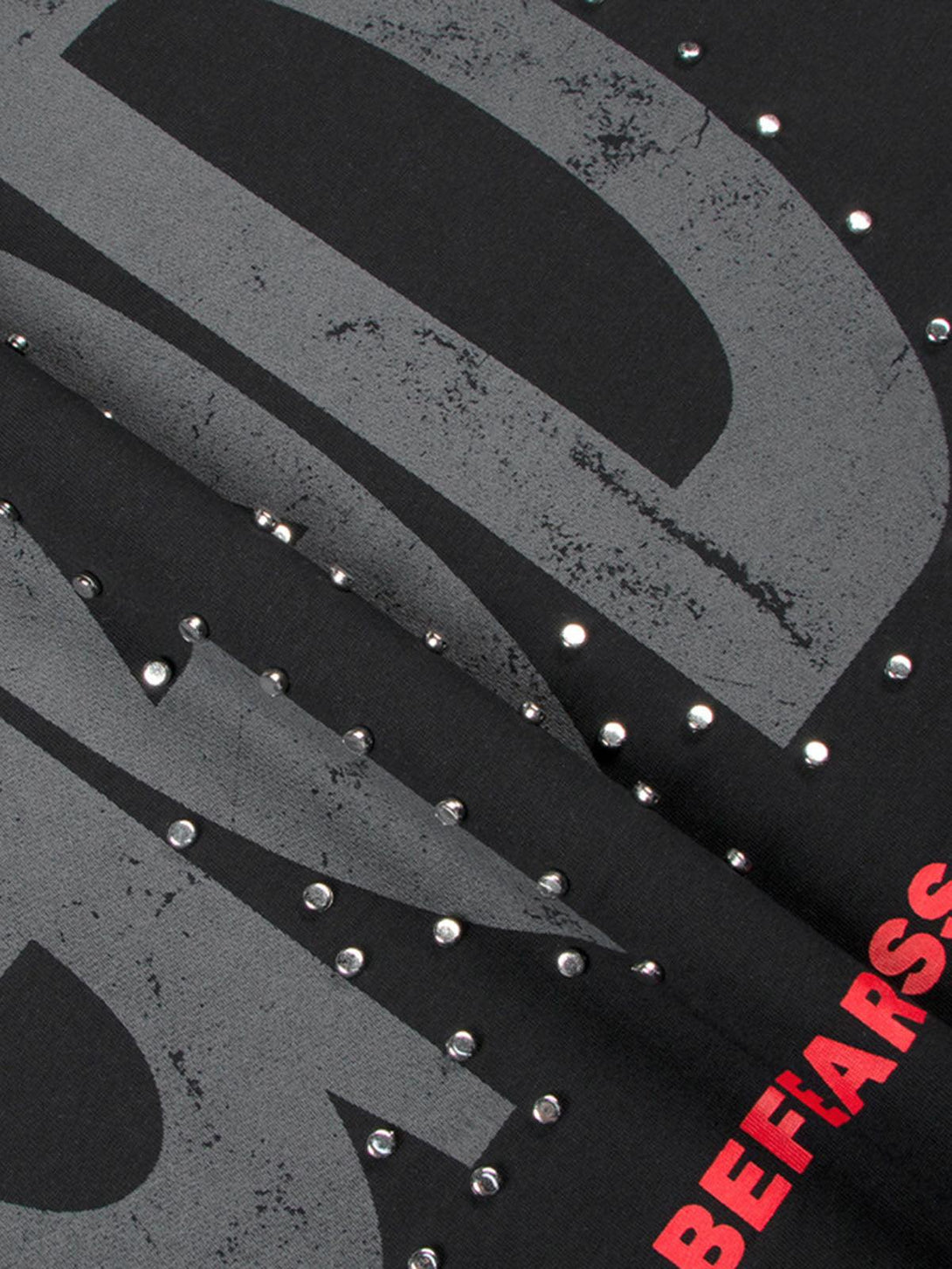 Detailed view of TALISHKO T-shirt, showcasing bold "BEFEARLESS" print and stud embellishments.