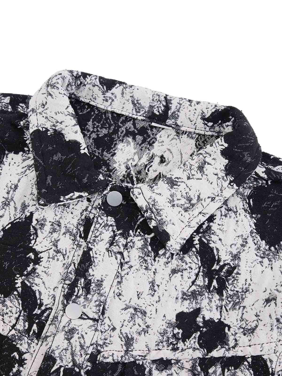 Zoomed-in texture of TALISHKO's black and white floral denim jacket collar and buttons.