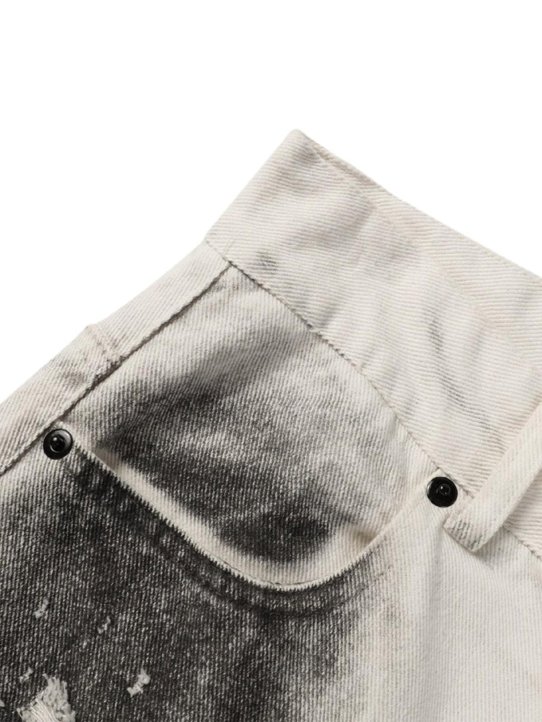 Zoomed-in texture of white jeans with black stain effect, featuring TALISHKO's edgy design.