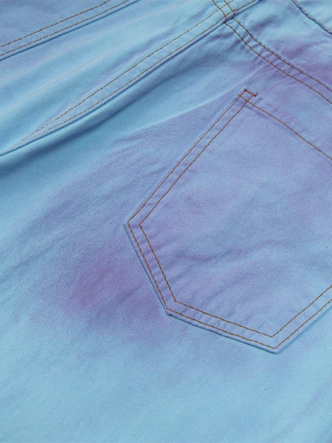 A detailed view of TALISHKO blue and purple jeans, highlighting the gradient pocket design.