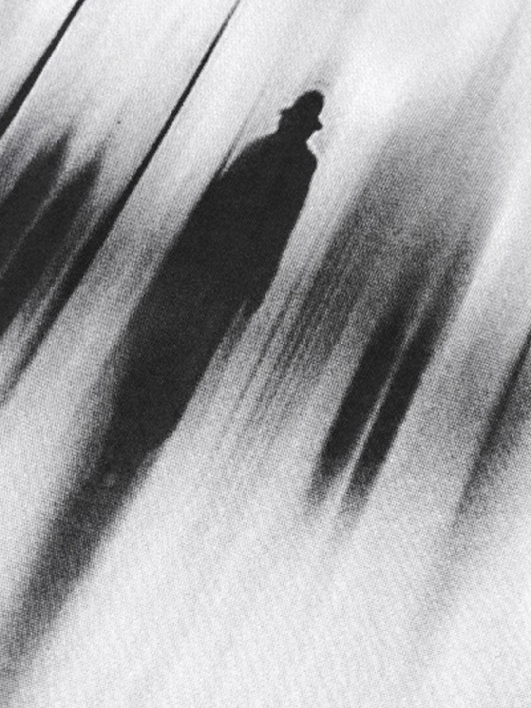 Shadowy figure on a fabric texture, evoking mystery in TALISHKO's artistic design.