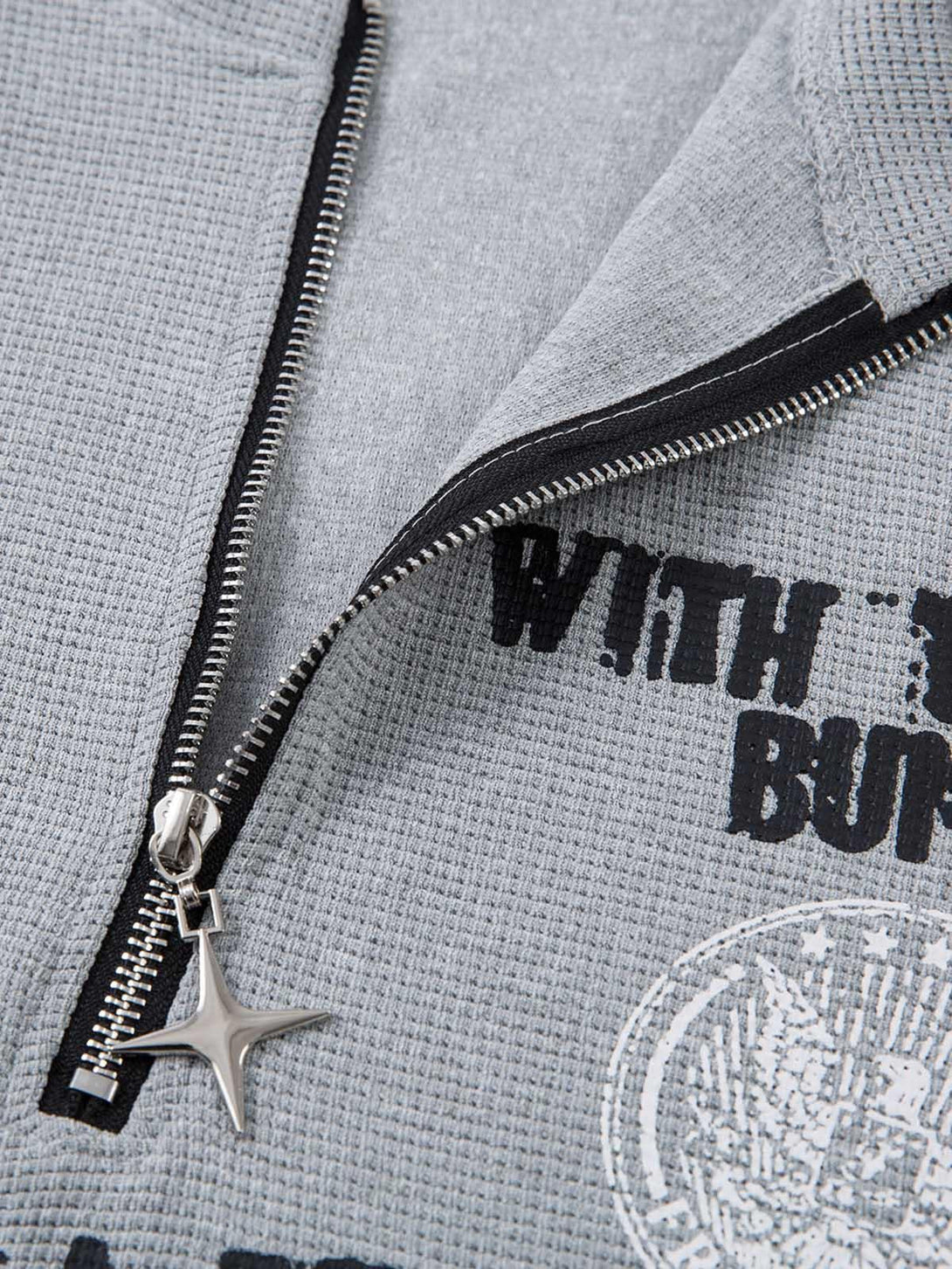 Intricate design detail of TALISHKO gray T-shirt featuring bold graphics and a star zipper pull.