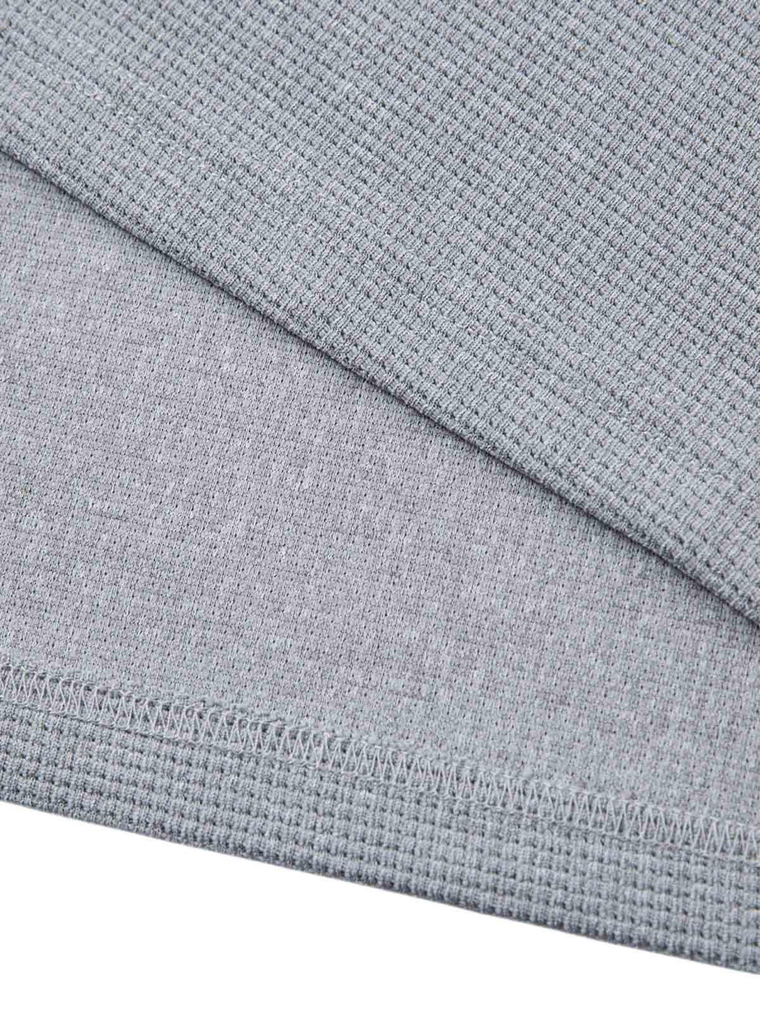 Texture and stitching details on TALISHKO gray T-shirt, showcasing intricate fabric design.