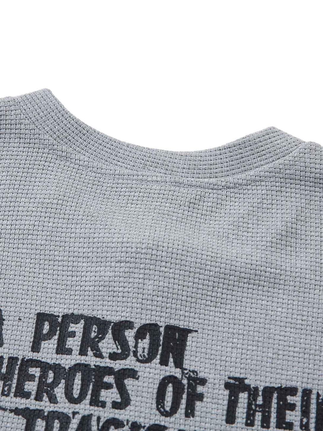 Zoomed-in texture of TALISHKO gray T-shirt highlighting bold statement graphics.