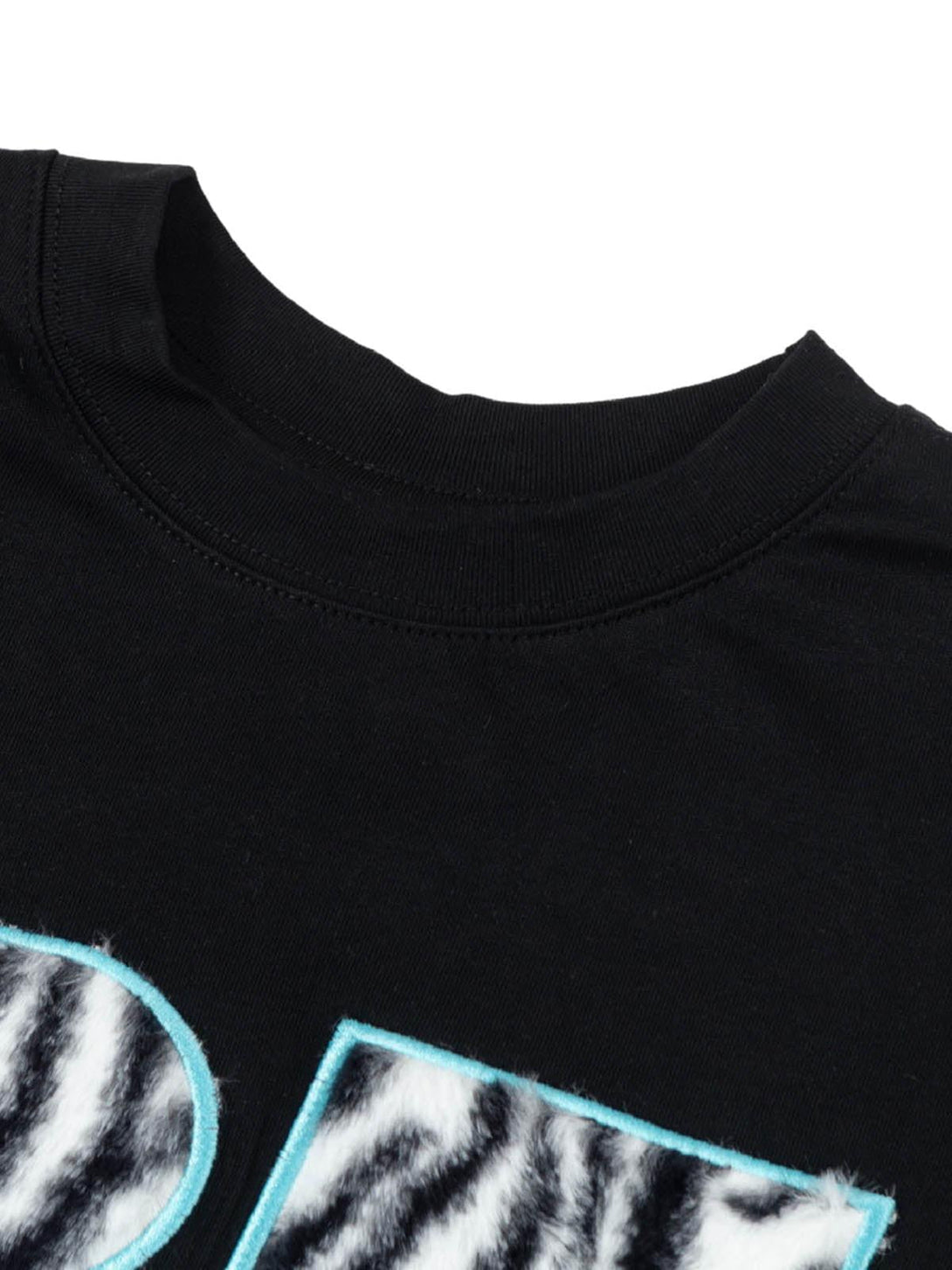 Zoomed-in texture of zebra print detail on a black graphic T-shirt by TALISHKO.