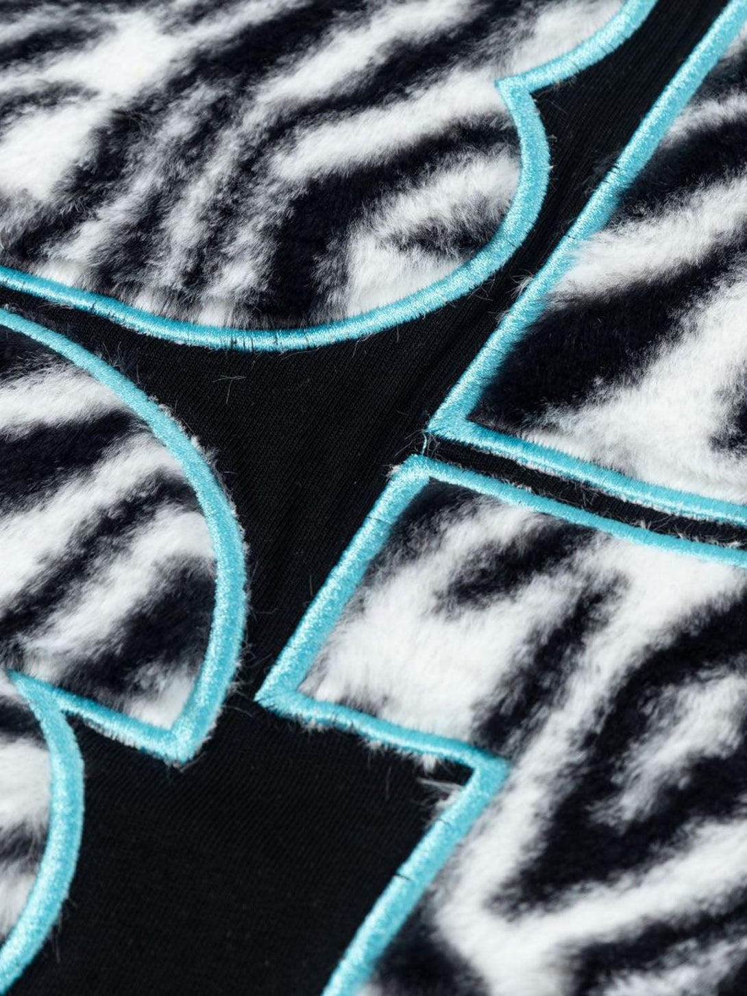 Intricate look at bold zebra pattern with turquoise accents on a graphic T-shirt by TALISHKO.