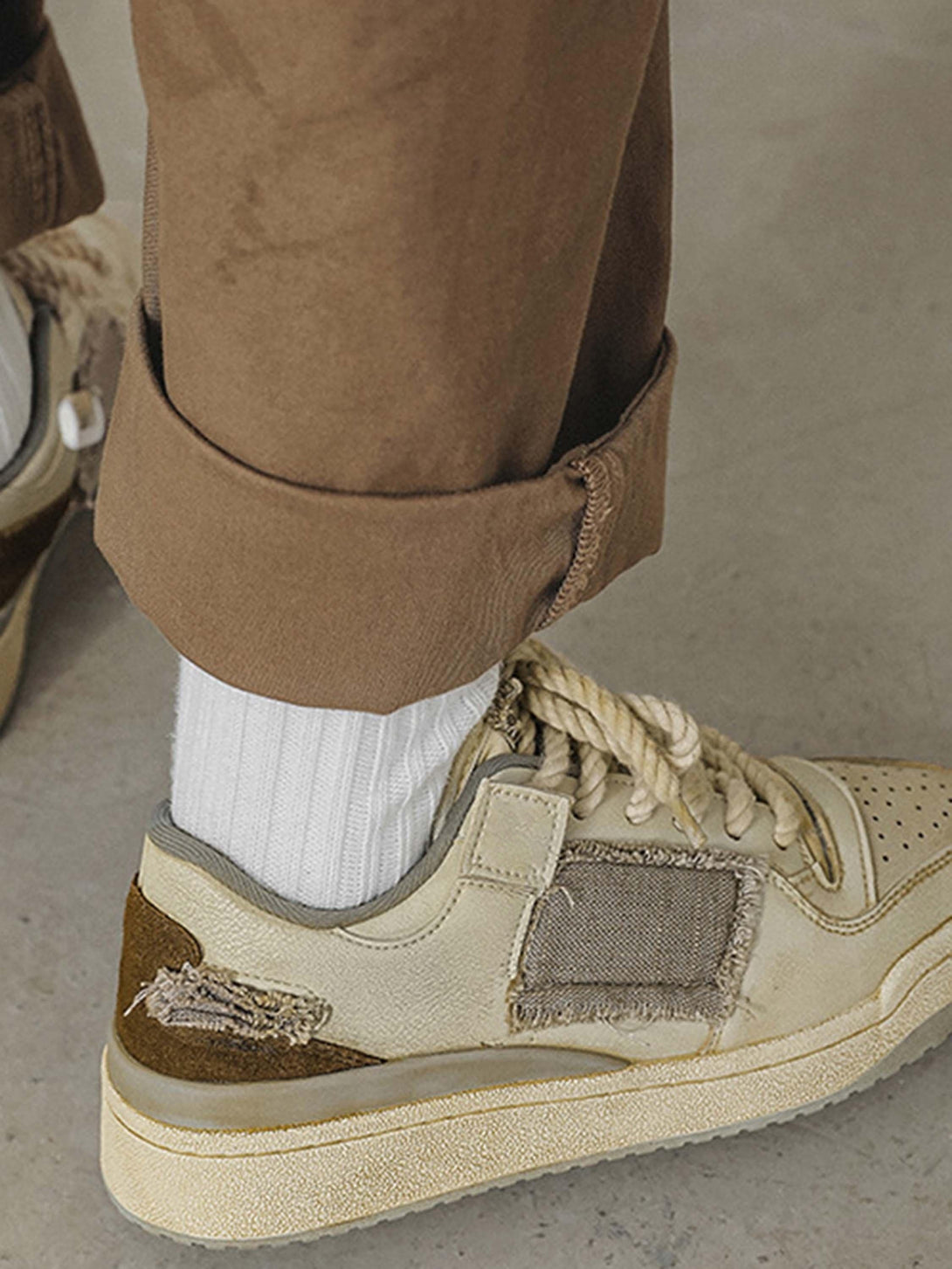 Casual shoes by TALISHKO paired with rolled-up pants, showcasing a rugged, textured design.