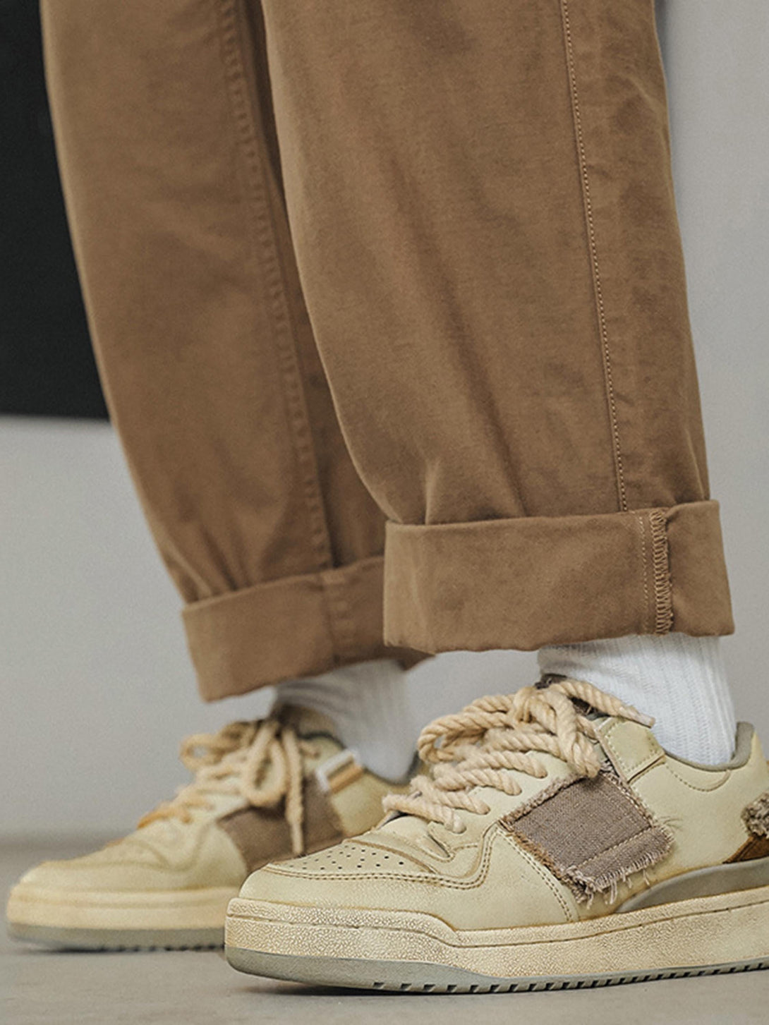 Stylish casual shoes by TALISHKO paired with rolled-up brown pants, highlighting a unique design.