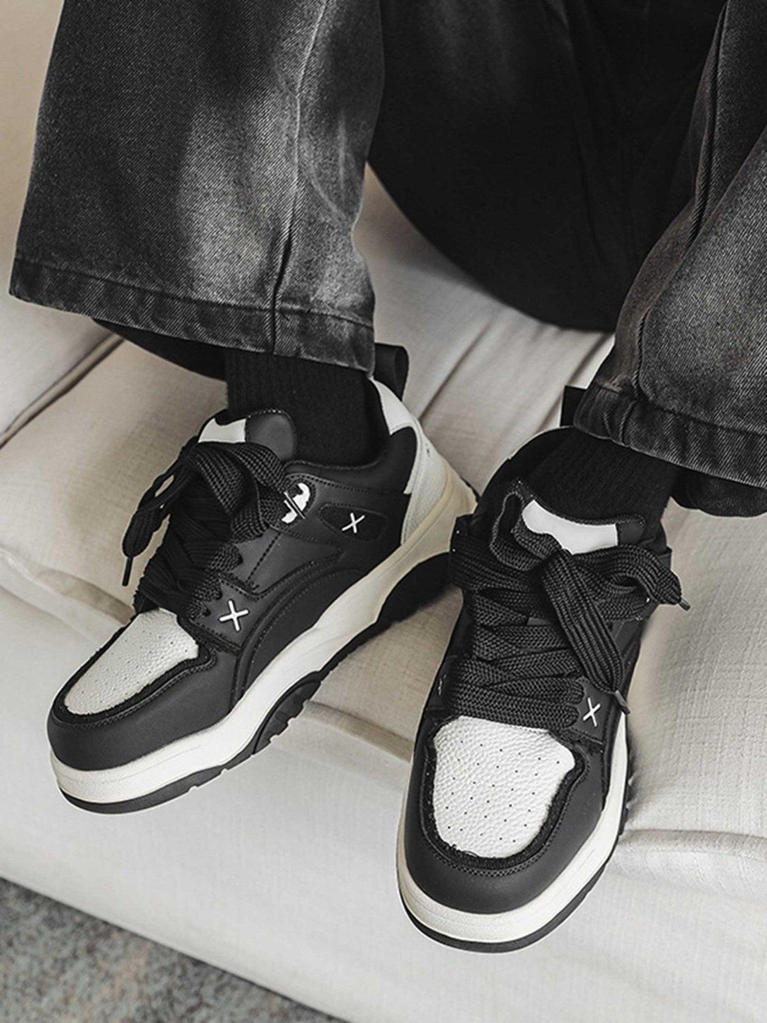 TALISHKO board shoes in black and white, styled with casual denim for a modern look.