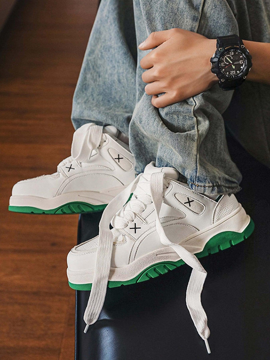 A person wearing TALISHKO white board shoes with green soles, styled with casual denim.