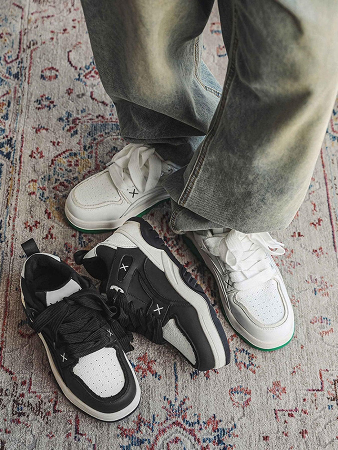 A stylish mix of TALISHKO black and white board shoes paired with relaxed denim on a patterned rug.