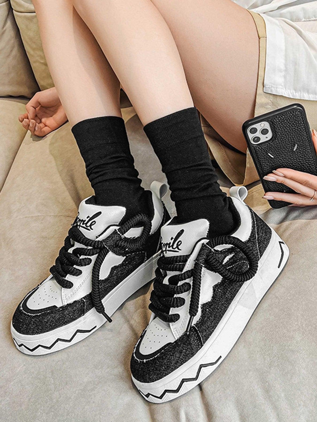 TALISHKO canvas sneakers with bold zigzag soles in black and white, paired with black socks.