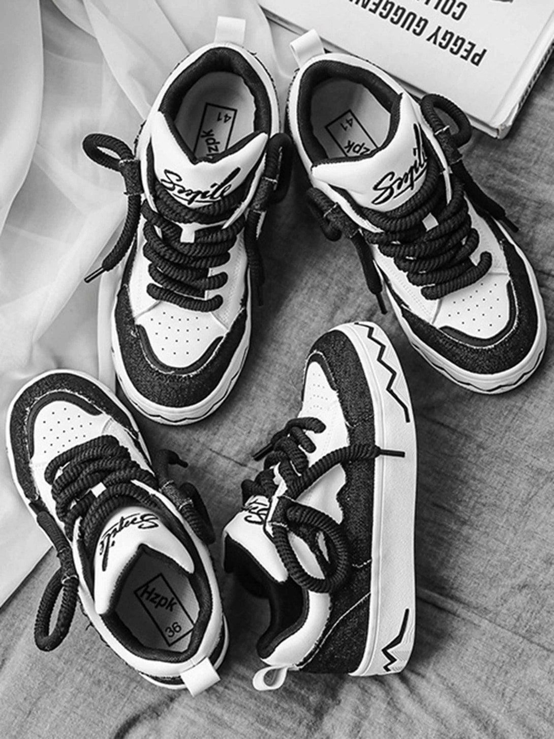 Black and white canvas shoes by TALISHKO, featuring bold zigzag sole details and contrast style.