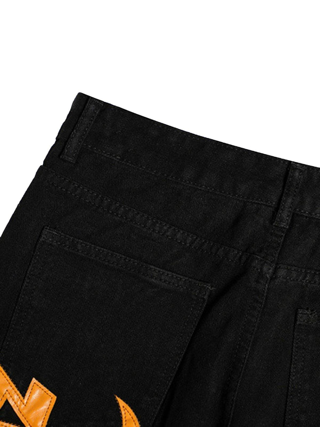 "Zoomed-in view of TALISHKO black jeans pocket with bold orange embroidery detail."
