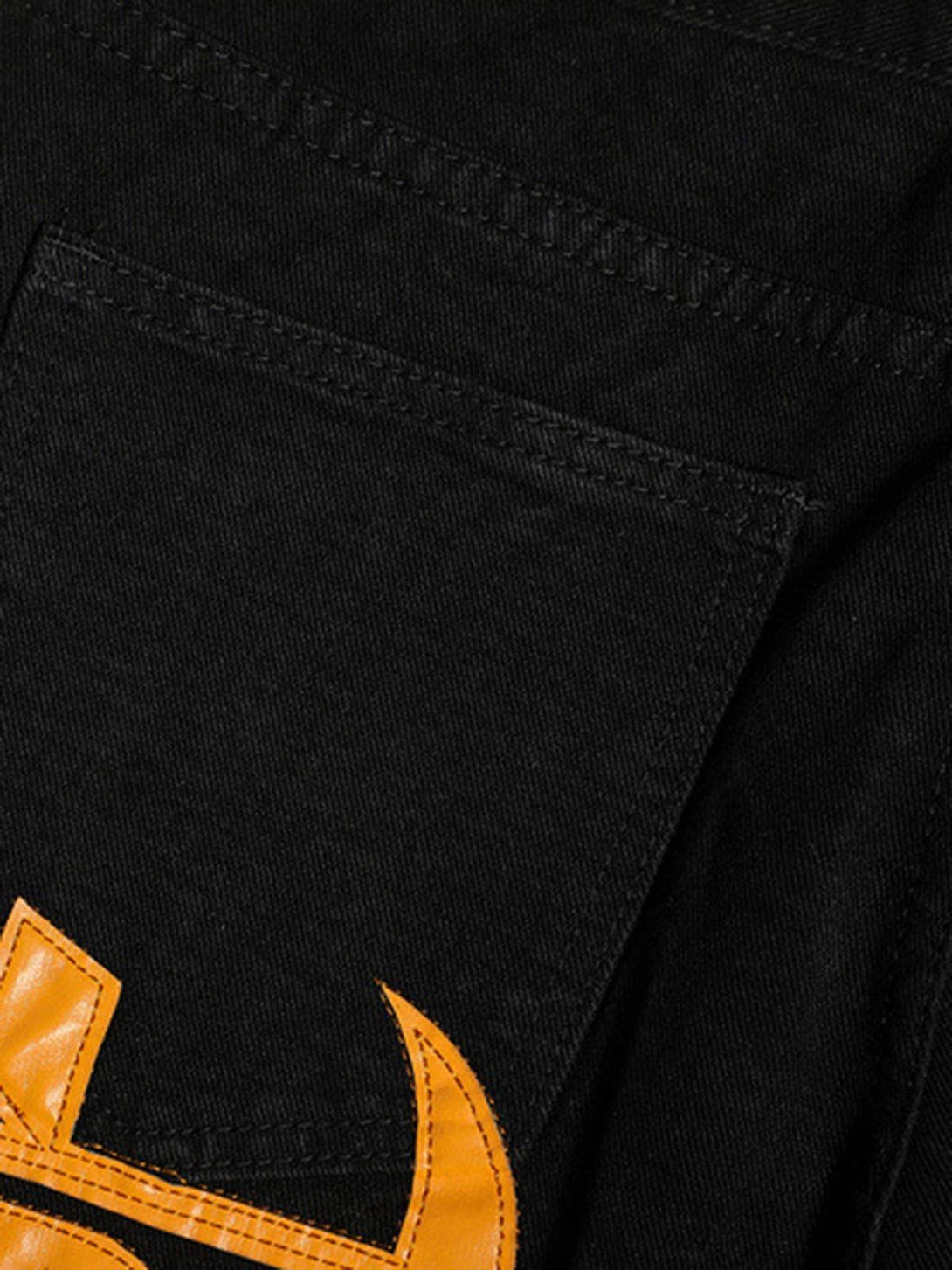 "Intricate look at TALISHKO black jeans pocket with bold orange embroidery, highlighting unique style."