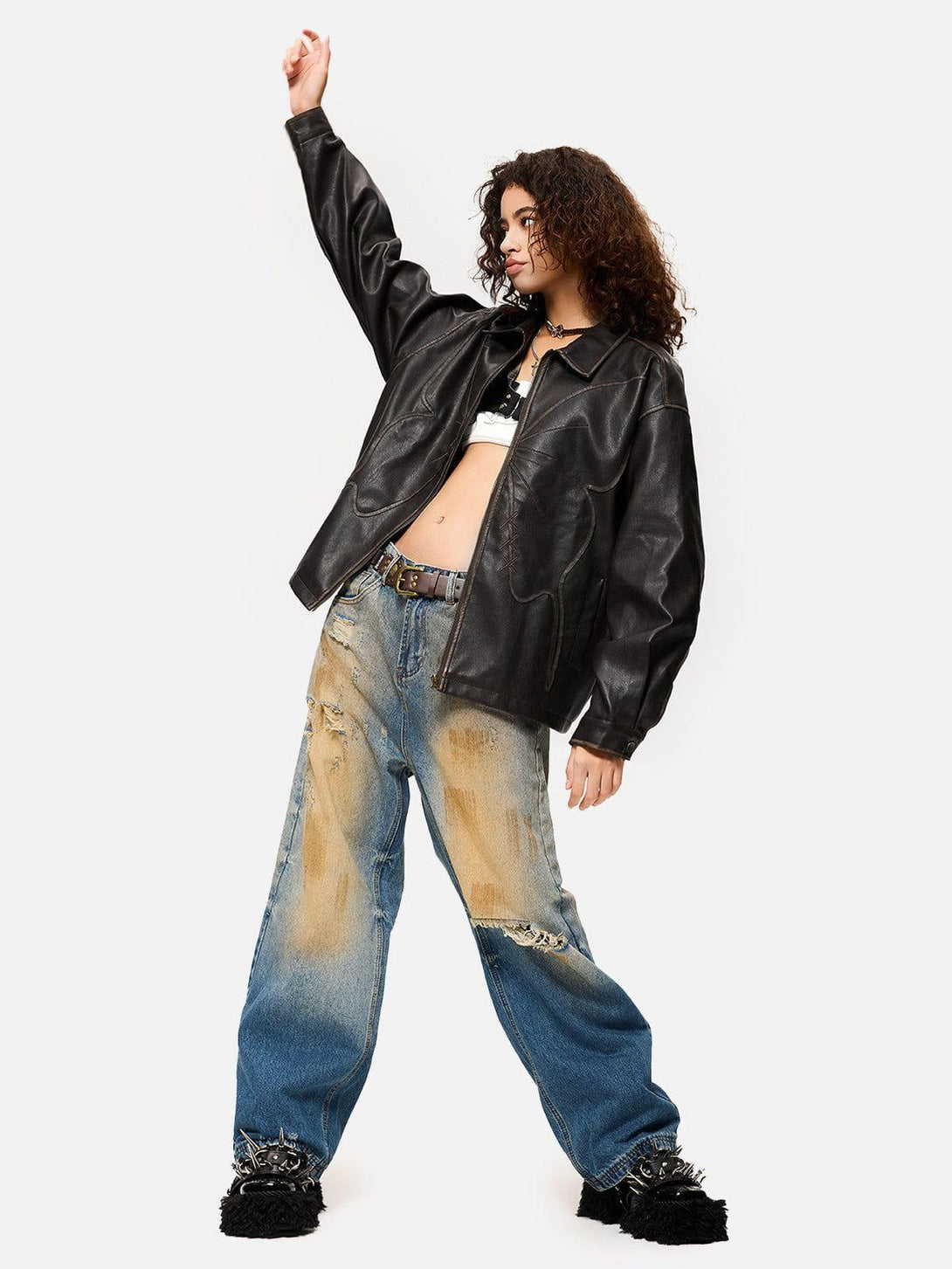 Model in TALISHKO butterfly faux leather jacket and distressed jeans, highlighting edgy fashion.