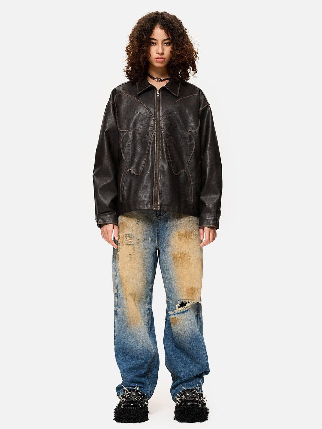 Model wearing TALISHKO butterfly faux leather jacket with distressed jeans, showcasing edgy style.