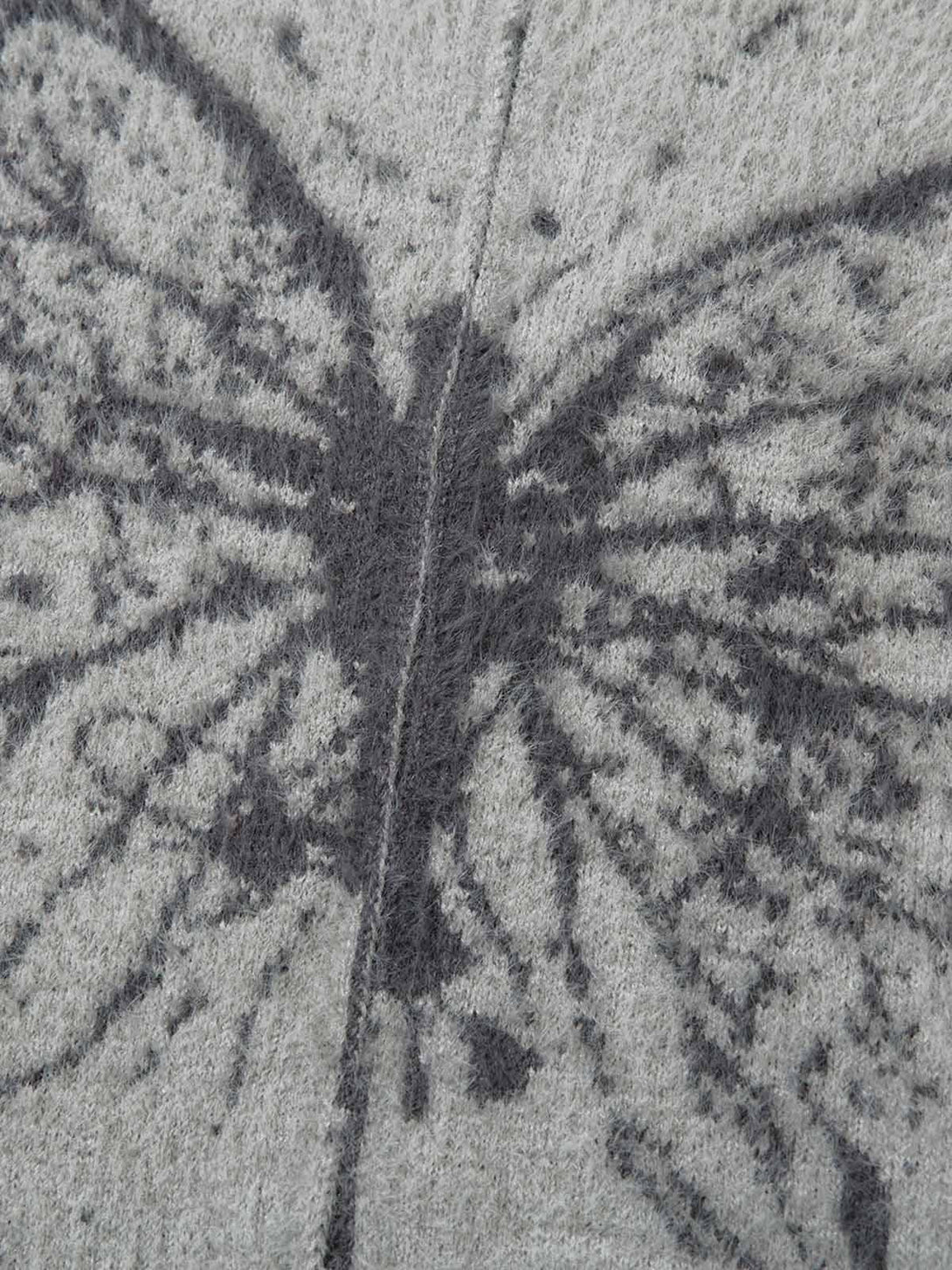 Zoomed-in texture of TALISHKO's butterfly jacquard knit sweater, highlighting intricate details.