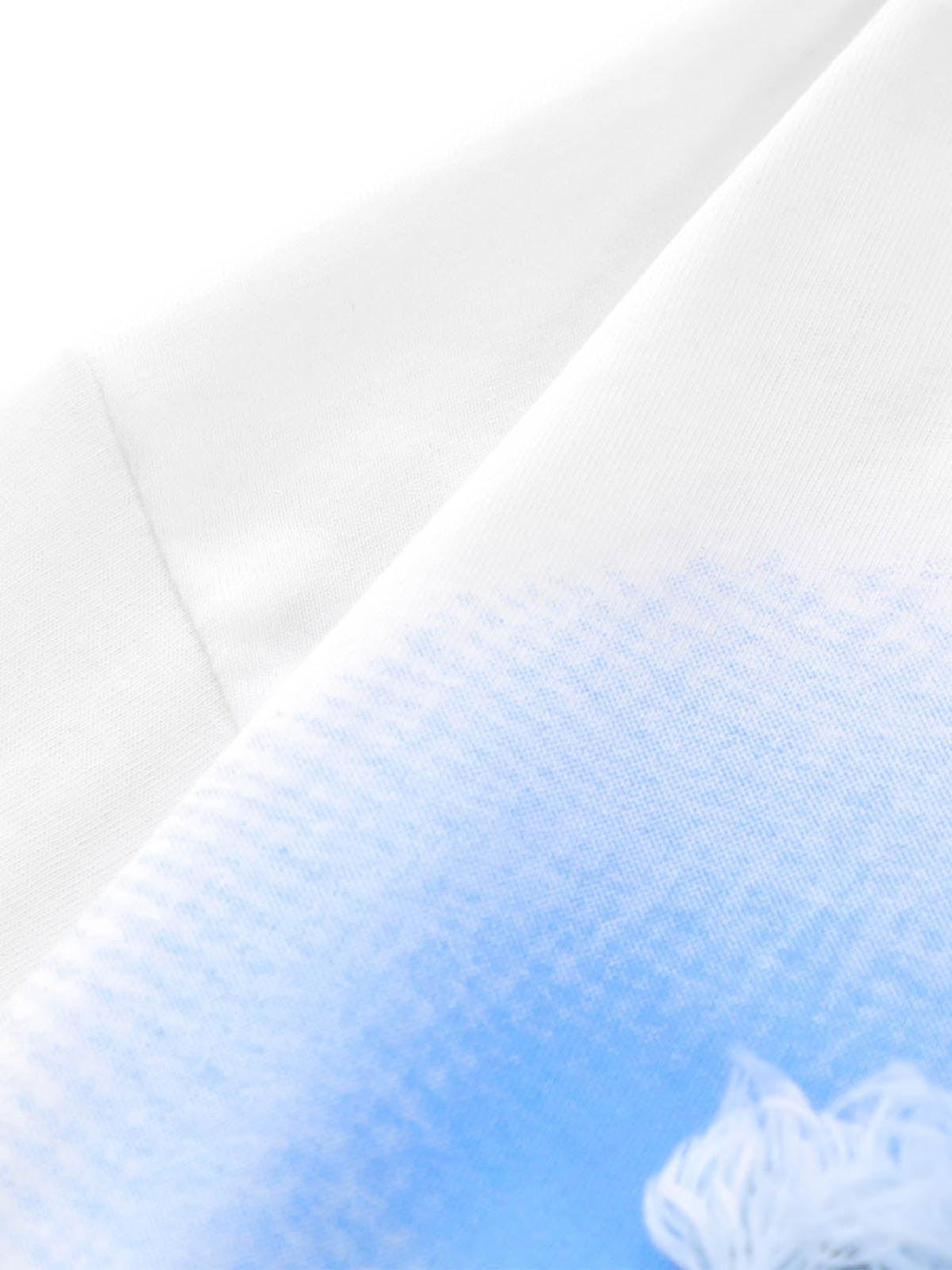 Zoomed-in texture of a white T-shirt with blue gradient detail by TALISHKO, showcasing fabric quality.