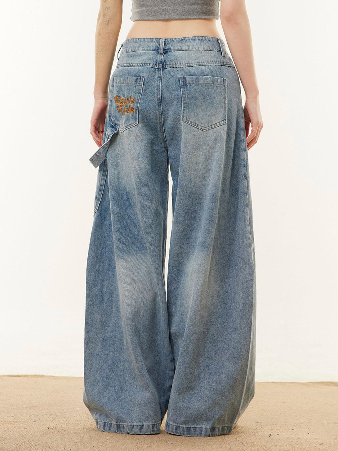 Back view of wide-leg barrel jeans by TALISHKO, showcasing unique embroidered pocket detail.