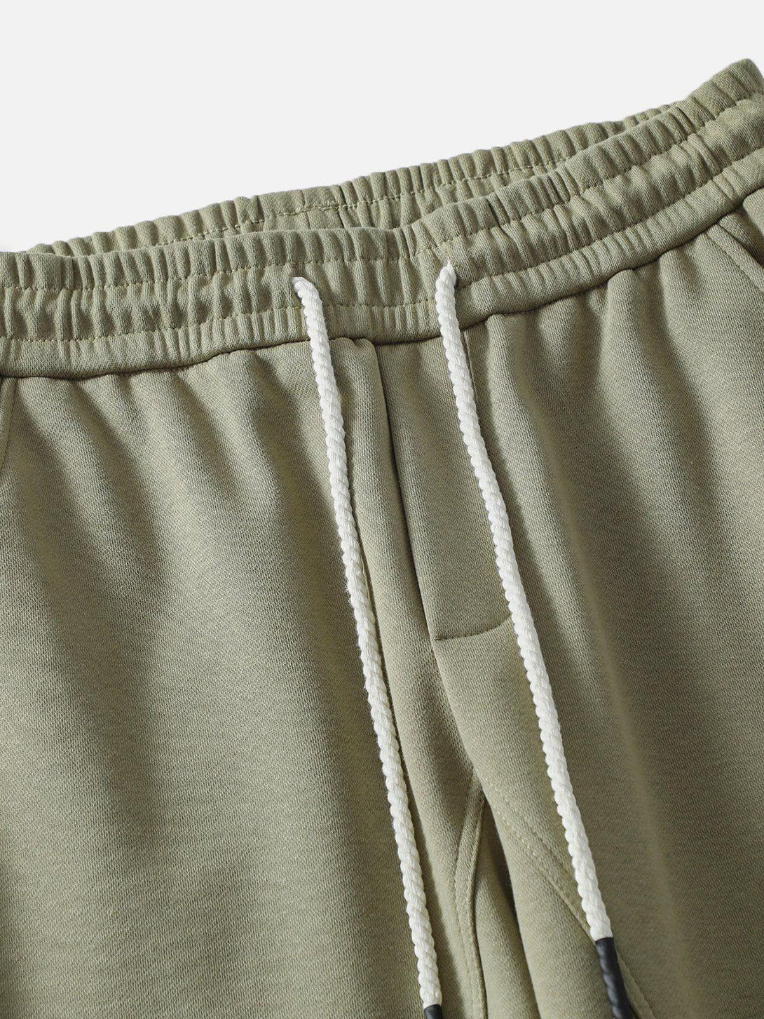 Focusing on the olive Camber Cutting Sweatpants by TALISHKO, showcasing drawstring detail.