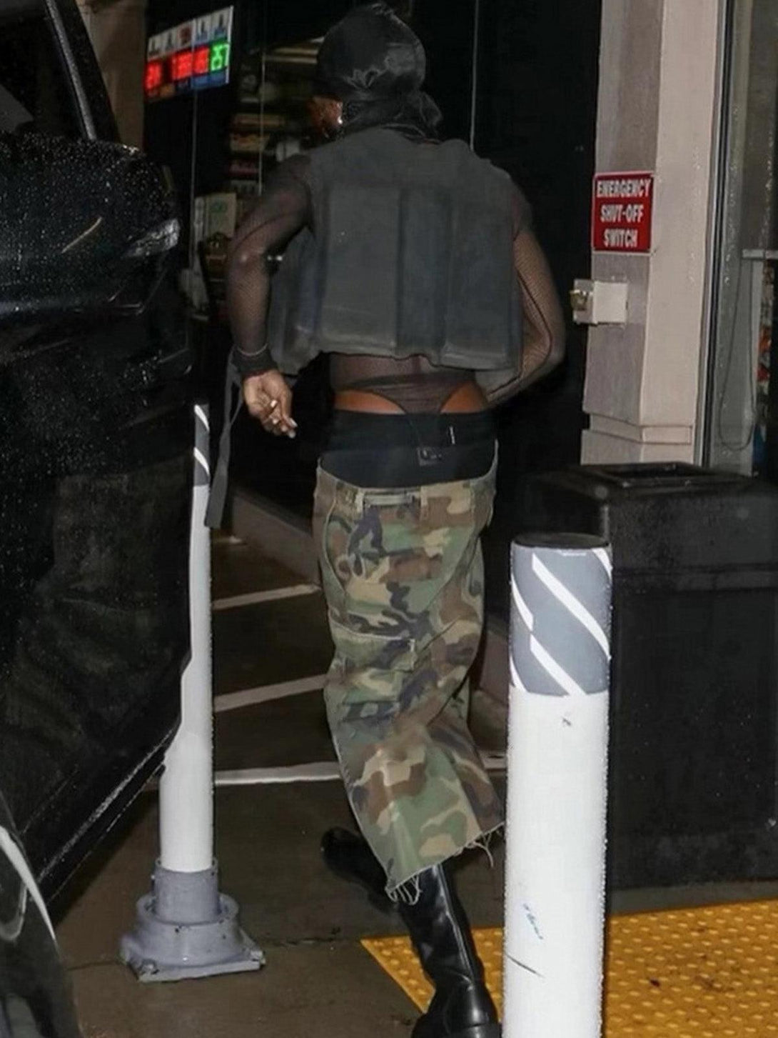 Back view of TALISHKO camouflage cargo shorts with buckle waist, paired with stylish black boots.