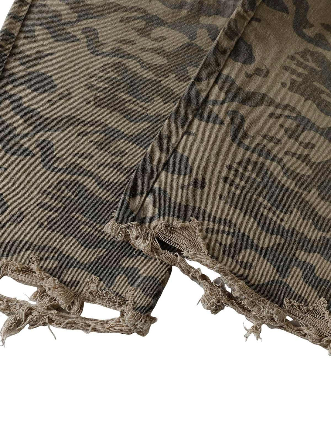 Frayed hem detail of TALISHKO camouflage cargo pants, showcasing rugged texture and style.