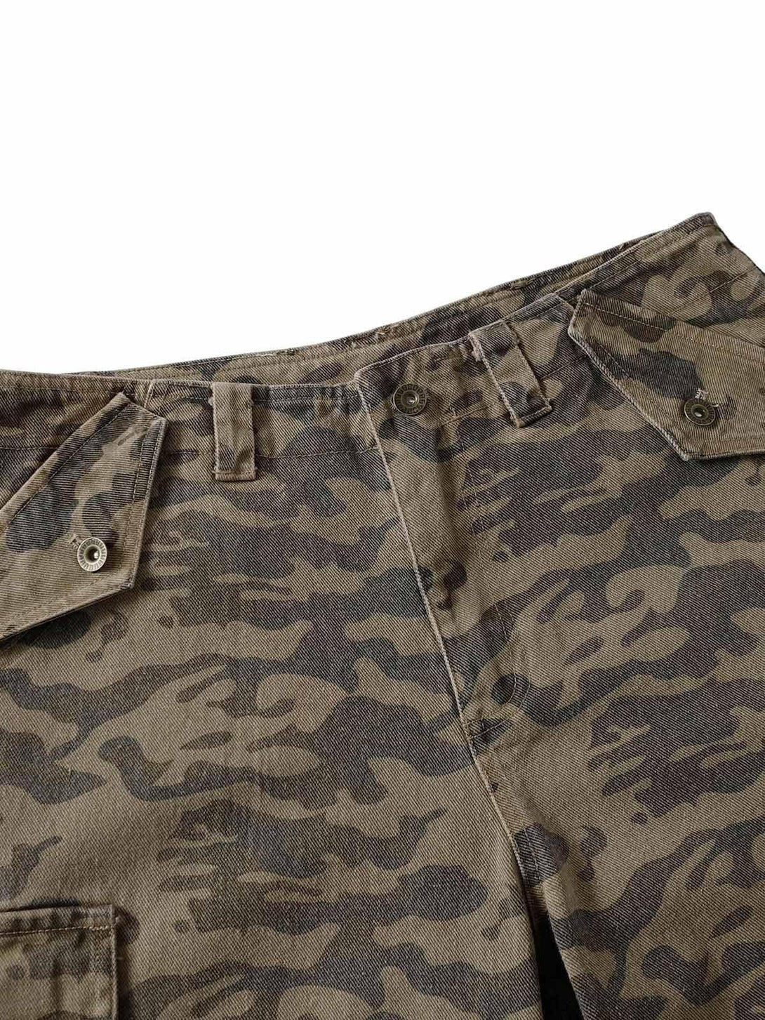 Detailed view of TALISHKO camouflage cargo pants, highlighting fabric texture and button details.