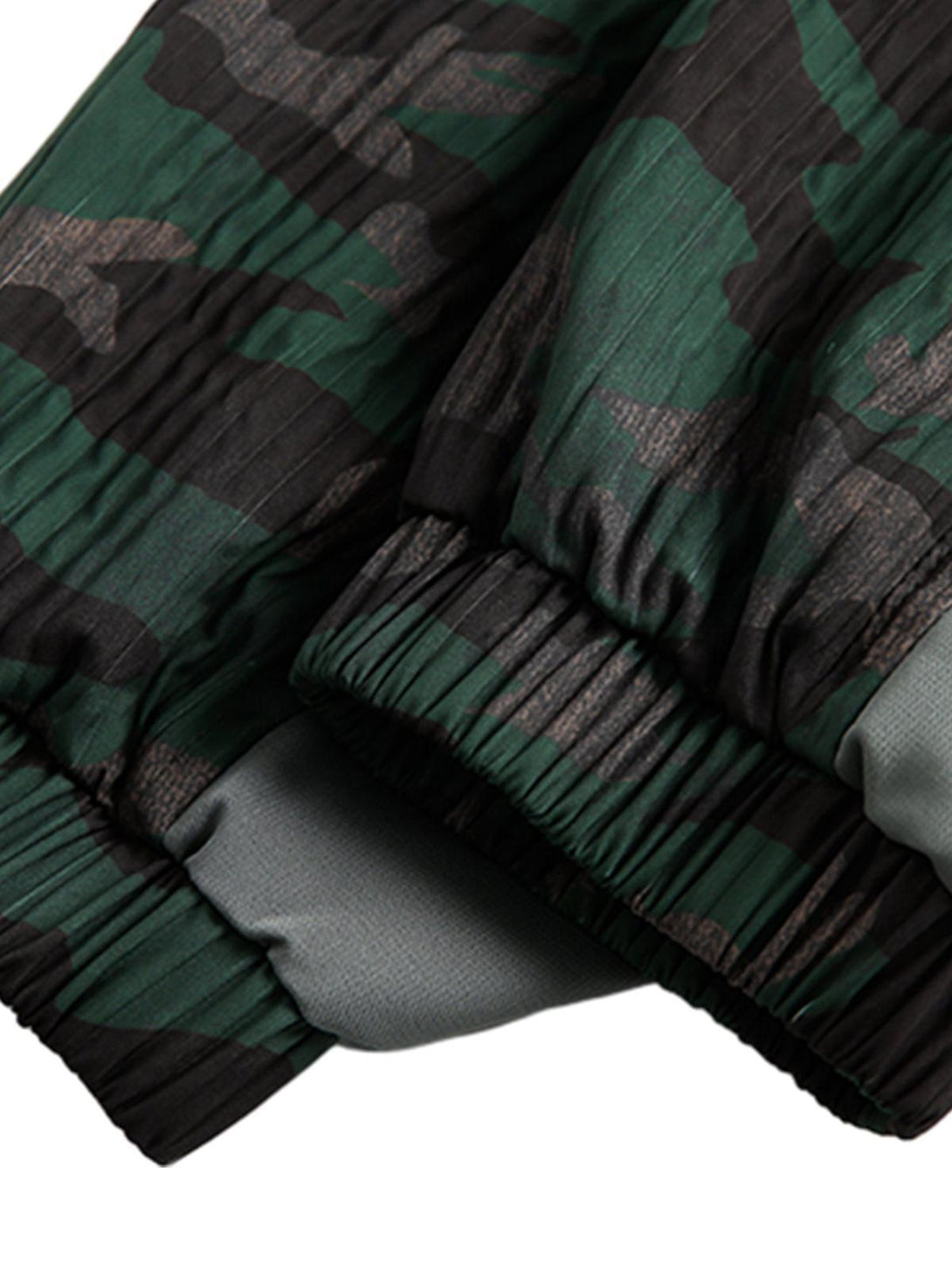 Detailed fabric and stitching of TALISHKO's camouflage diamond patchwork jacket.