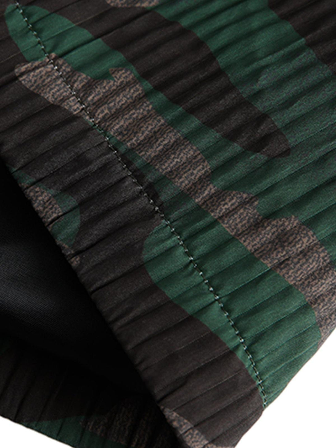 A detailed view of the camouflage pattern on TALISHKO's patchwork jacket, highlighting texture.