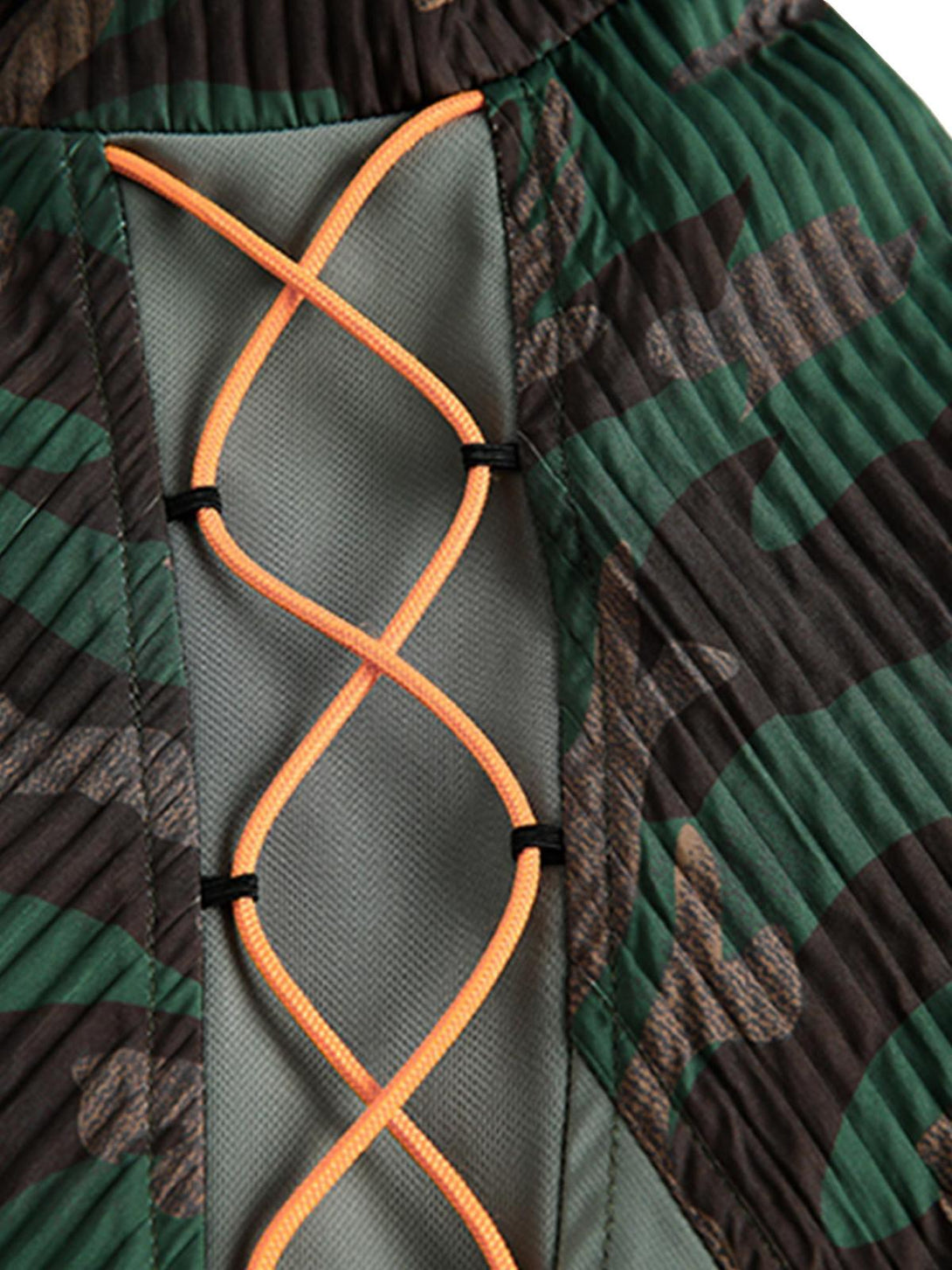 A tight crop highlighting the orange lace-up detail on TALISHKO's camouflage patchwork jacket.