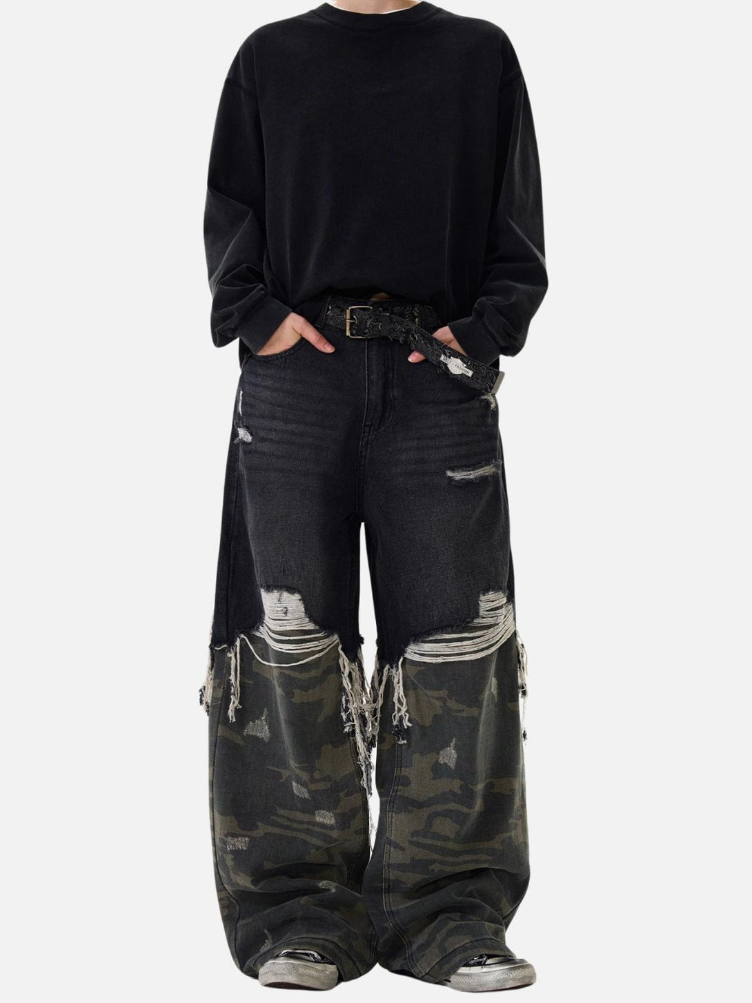 Model in TALISHKO distressed jeans with camo details, highlighting a unique, edgy look.