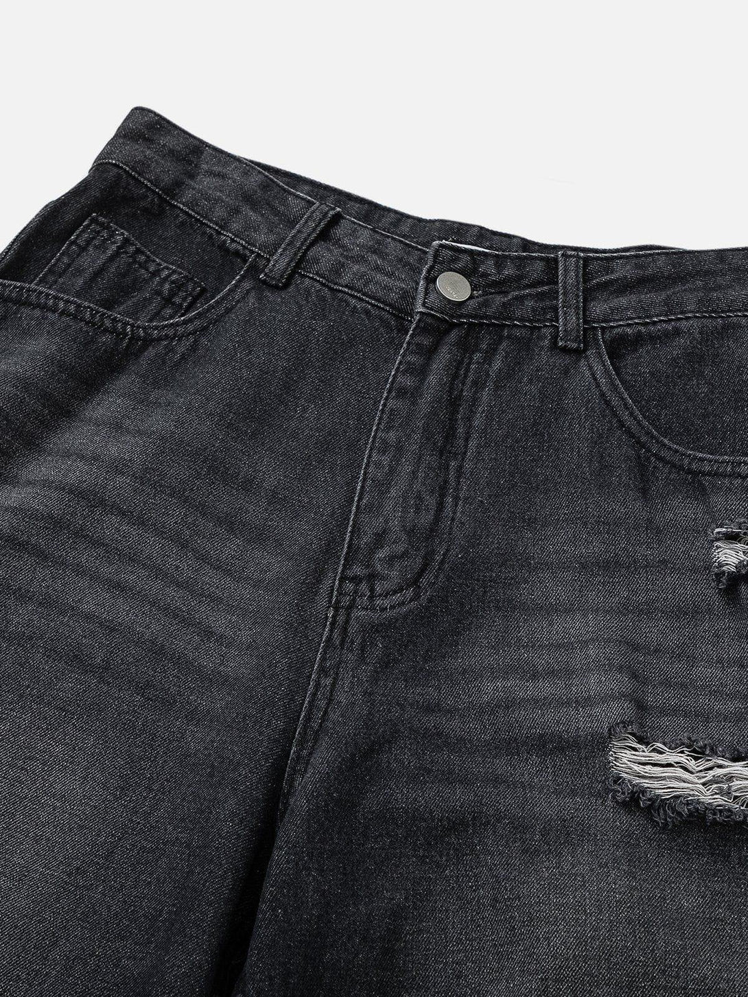 Focusing on the distressed details of TALISHKO jeans, highlighting their rugged texture.